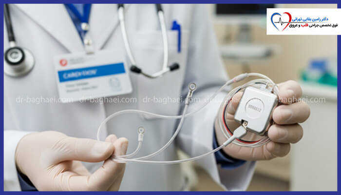 پزشک با دستکش سفید در حال نگه داشتن دستگاه مانیتورینگ قلبی کوچک (احتمالاً رویدادنگار) با سیم‌های متصل