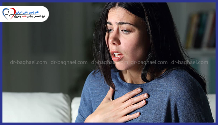 زنی با حالت پریشانی و تنگی نفس که دستش را به نشانه درد روی قفسه سینه خود قرار داده است